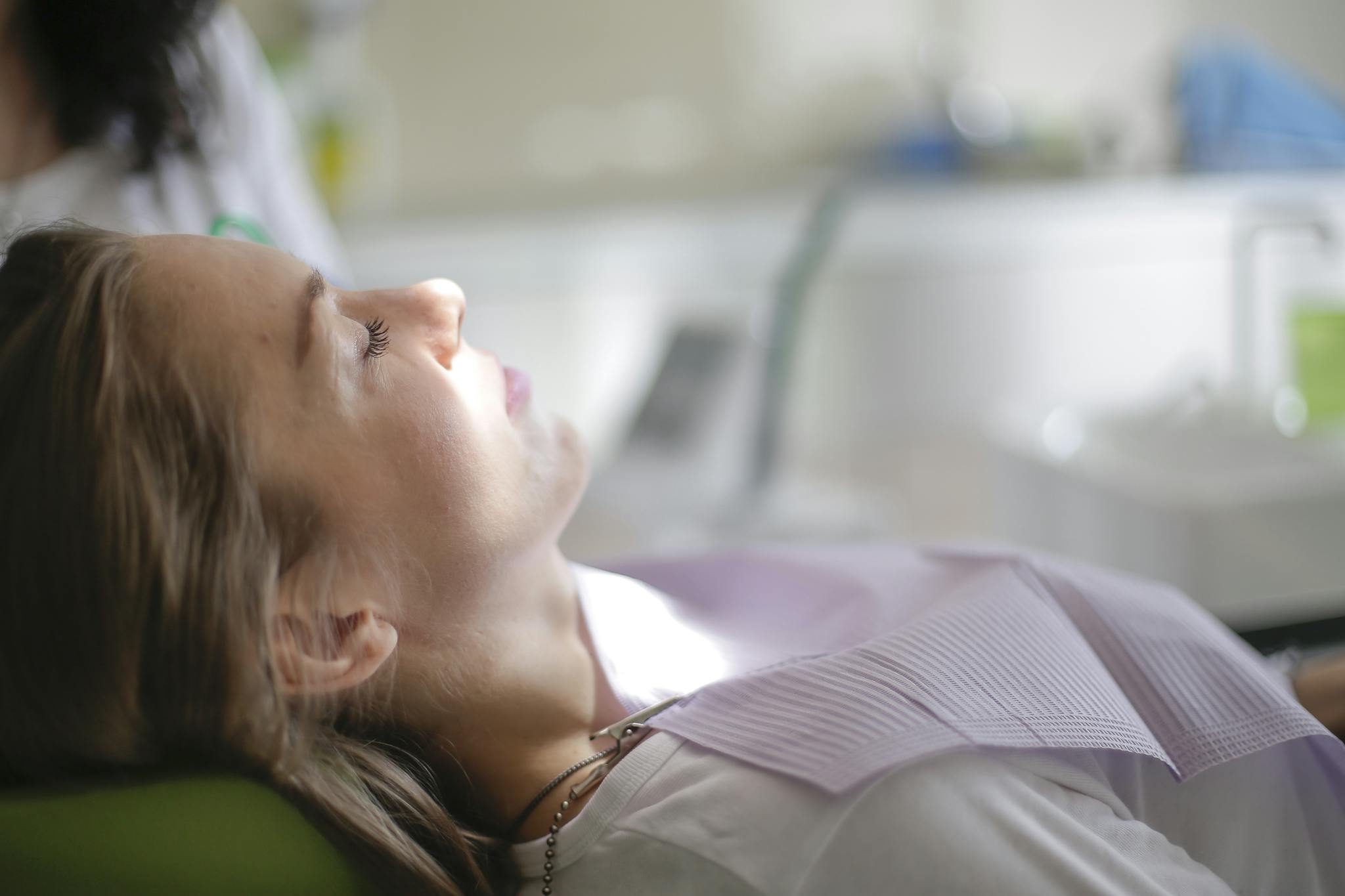 Woman lying calmly during a dental check-up in a modern clinic setting.